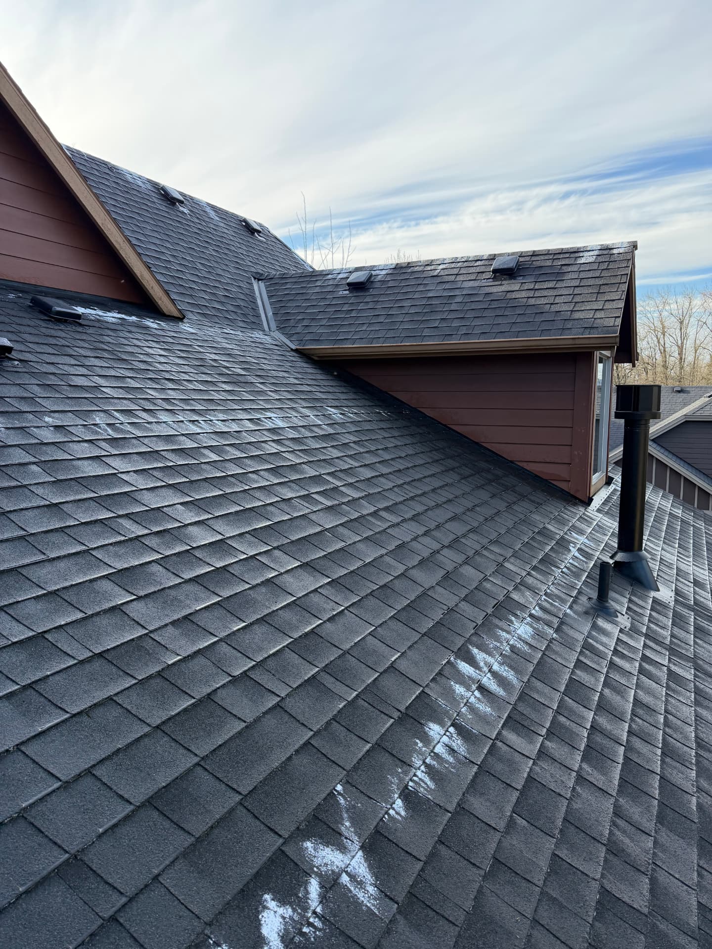 Completed asphalt shingle roof with vents and flashing after maintenance work