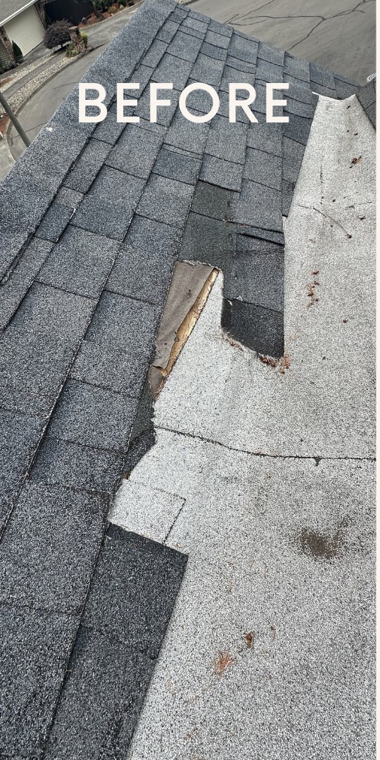 Torn and missing shingles at a roof ridge and valley before repair